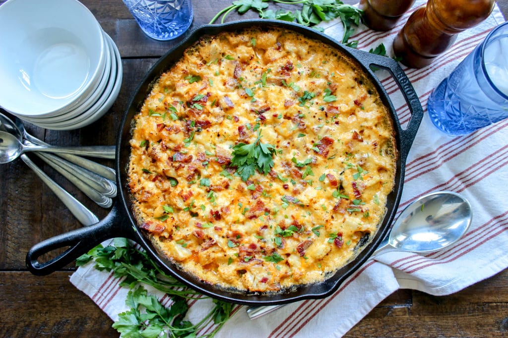 A pan of bacon cauliflower mac and cheese on a table.