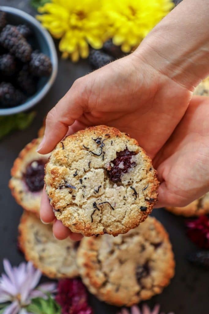 A close up of a person holding a keto early grey scone.