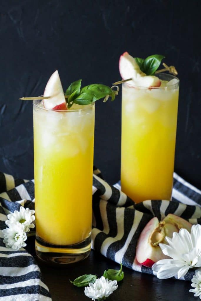 A keto fuzzy navel cocktail with two glasses on a table