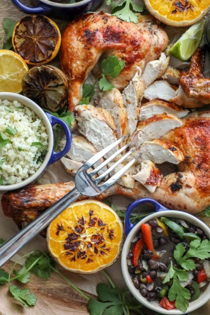 Mojo Roasted Chicken sliced on a platter with a fork.