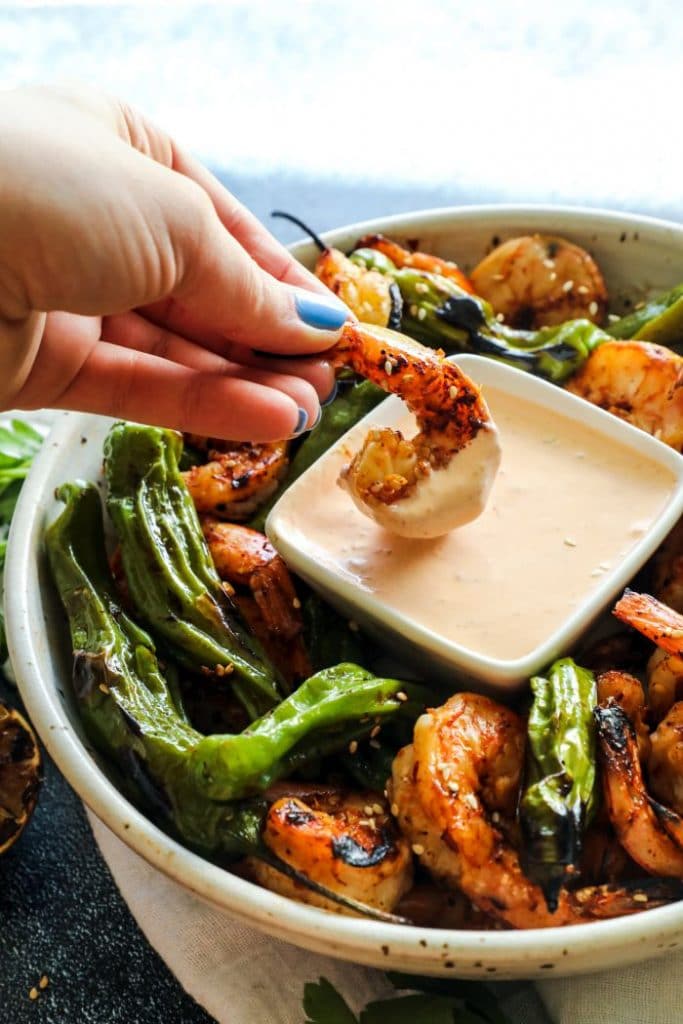 Shrimp being dipped into the chili sauce