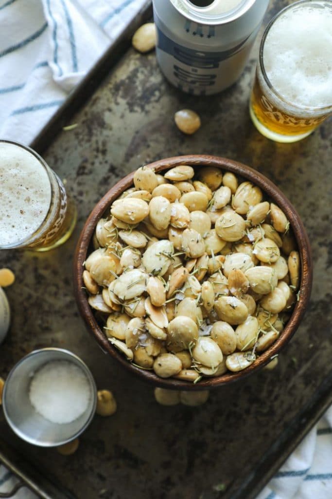 Herb Smoked Marcona Almonds with beer on a tray.