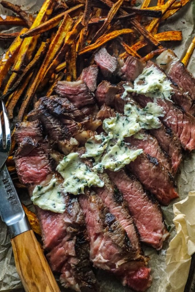 Sliced medium rare steak over jicama frites.