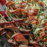 Char Grilled Cabbage Steaks and Smoked Sausage spiralized on a platter.