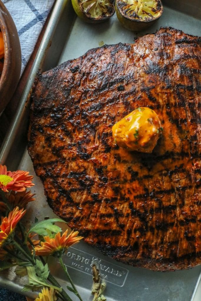 Easy Grilled Adobo Marinated Flank Steak with compound butter over the top.