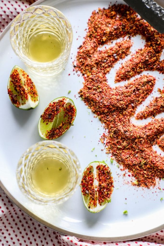 Easy Homemade Tajin Seasoning Recipe on limes with shots of tequila.