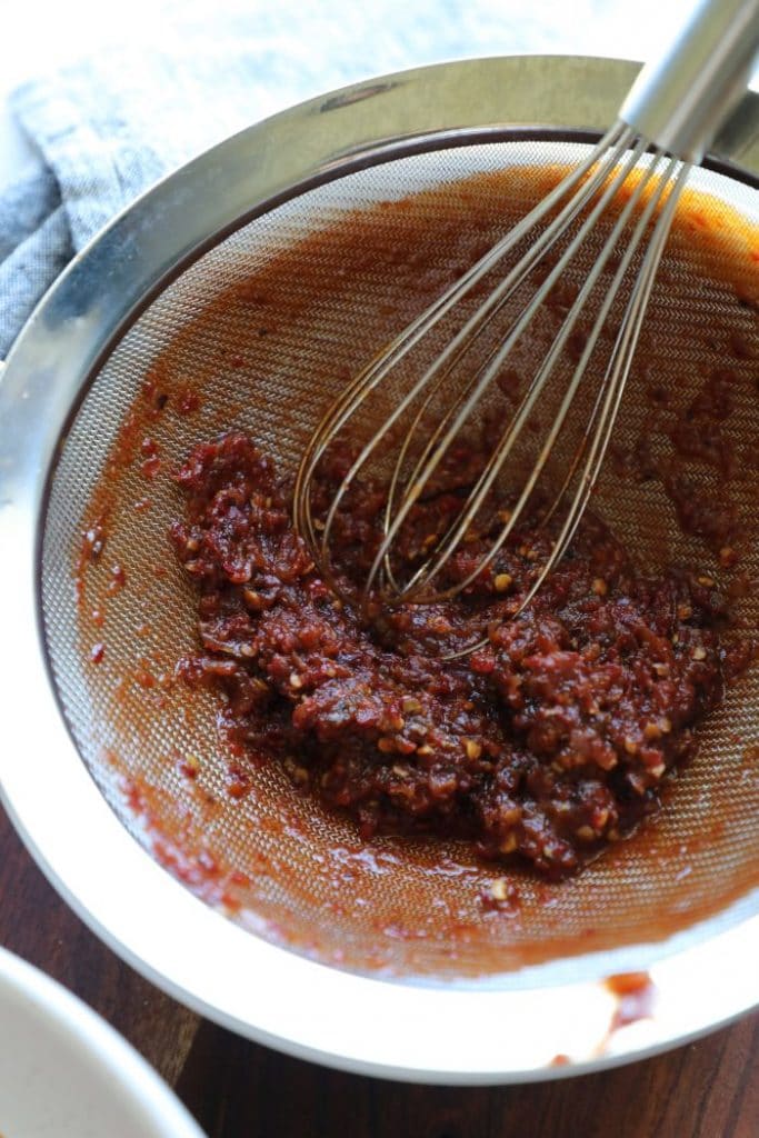 Adobo peppers in a strainer