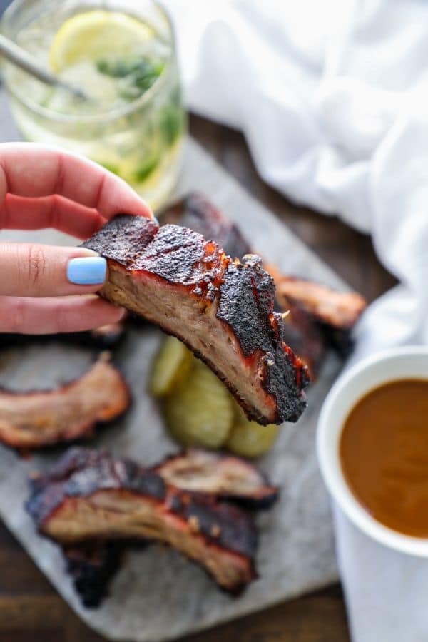 slow smoked ribs 3-2-1  held in a hand