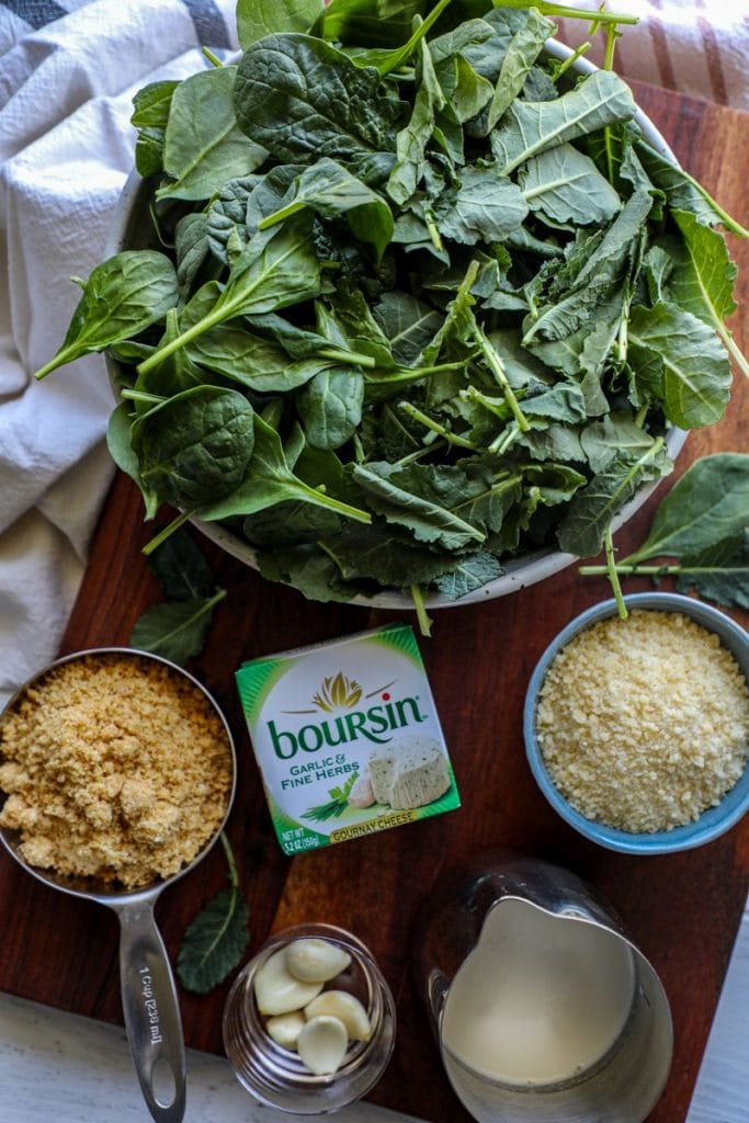 spoonful of Keto Creamed Spinach with Boursin Cheese ingredients on a brown board
