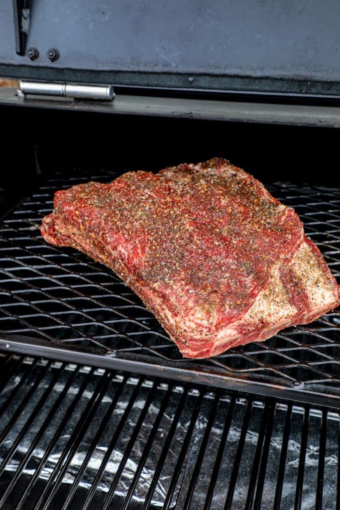 Beef plate ribs seasoned and on the smoker