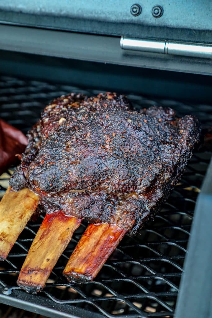 Beef ribs smoking on a grill and building bark