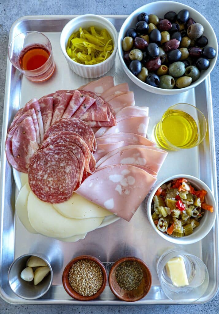 ingredients to make a muffuletta sandwich on a tray
