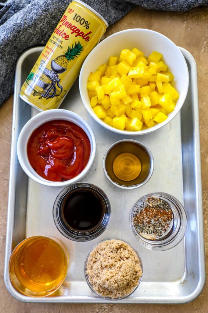 Ingredients needed for pineapple BBQ sauce set out on a baking sheet.