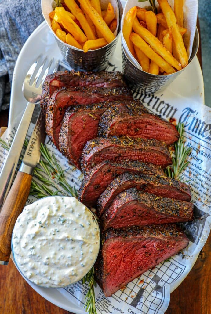 Smoked Bottom Round Roast Recipe served with horseradish sauce on the side.