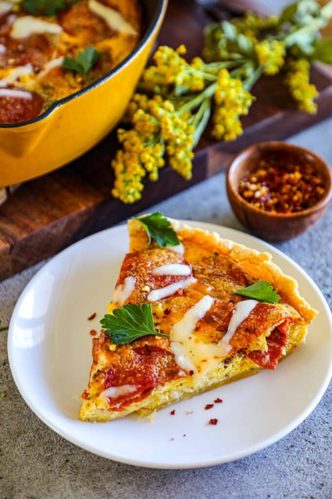 A slice of cast iron quiche on a white plate