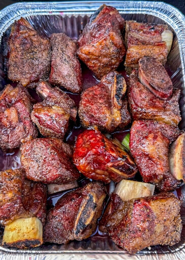 Braising the smoked beef short ribs in red wine in a foil pan