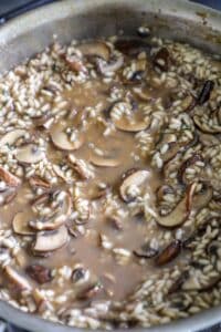 Adding the stock to the mushroom risotto