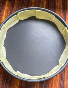 Cheese slices around the edge of the cast iron pan