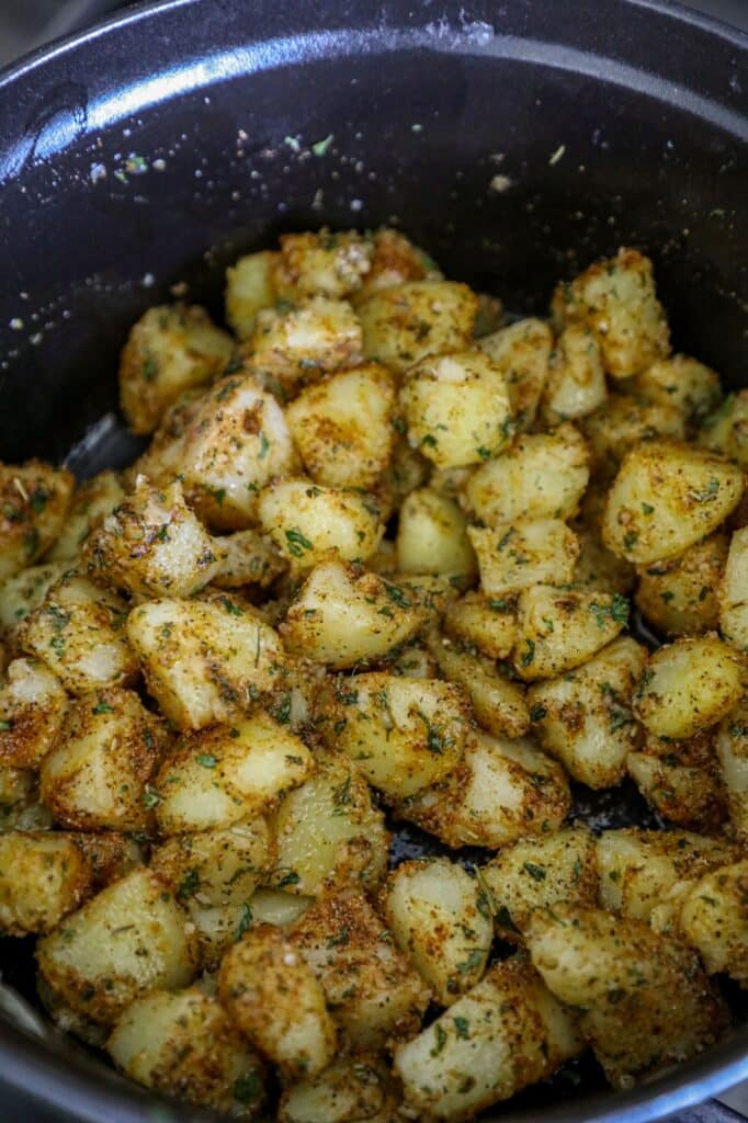 Seasoning the potatoes with butter, oil, and dried spices