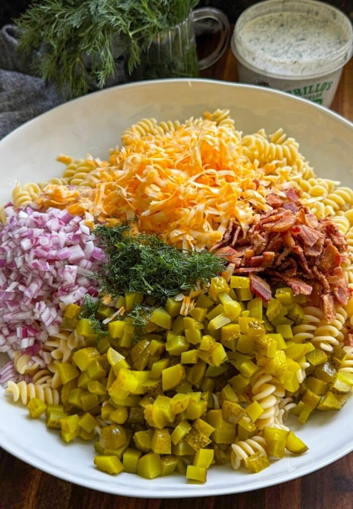 Combing the cooked pasta with the dill pickle pasta salad ingredients