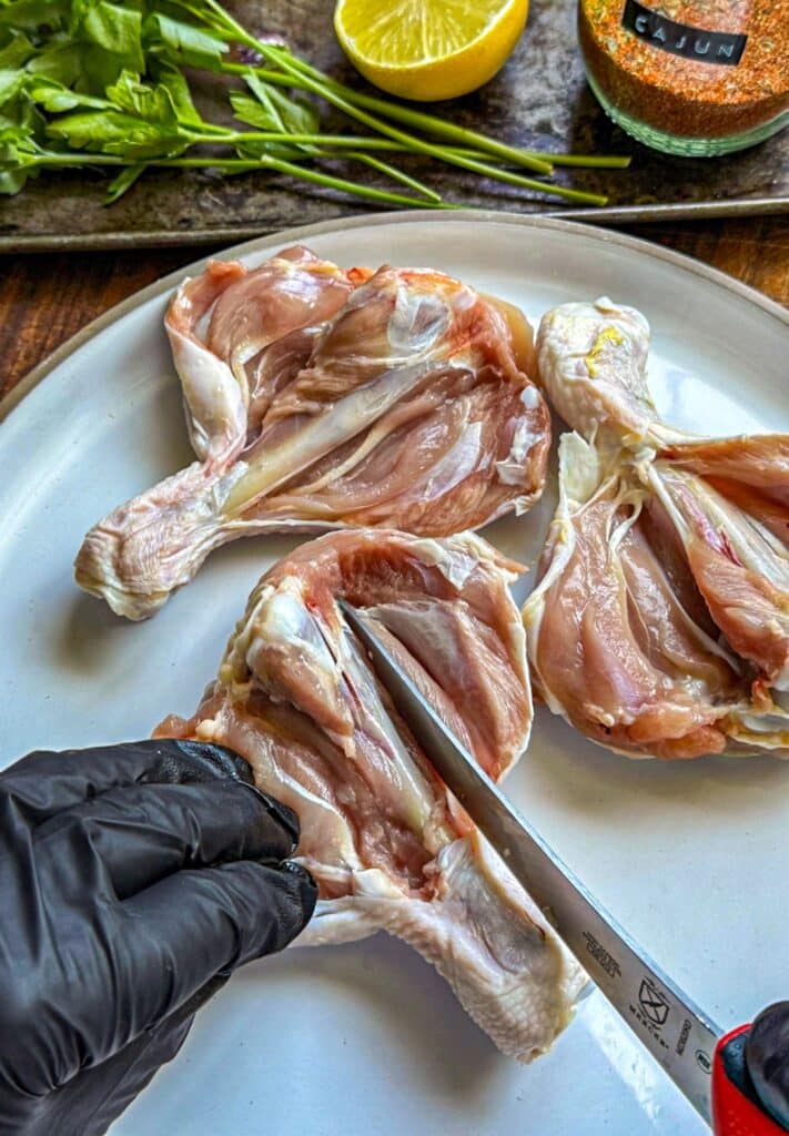 slicing around the bone to butterfly the chicken leg