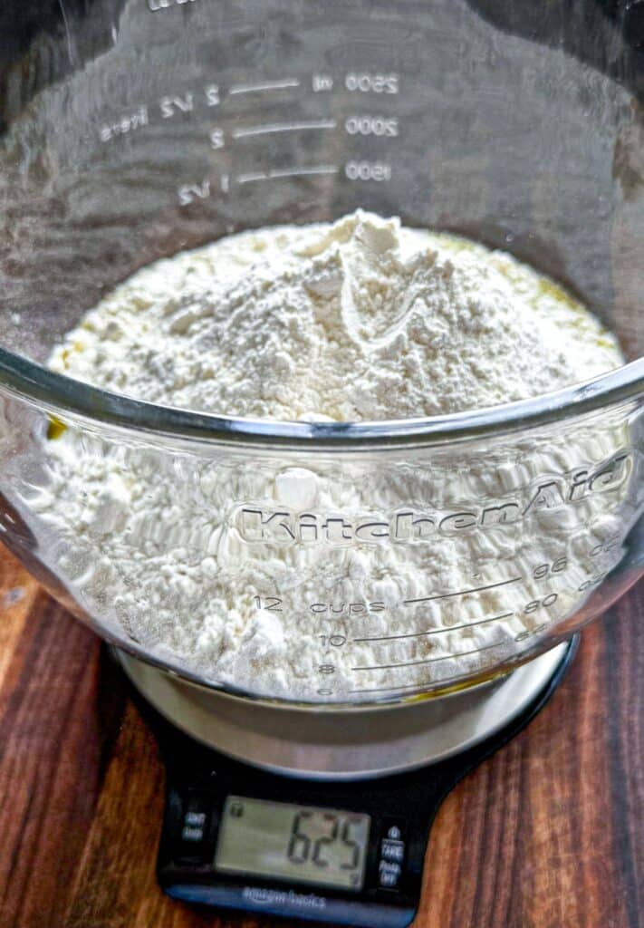 ingredients for the focaccia added to a glass bowl before mixing
