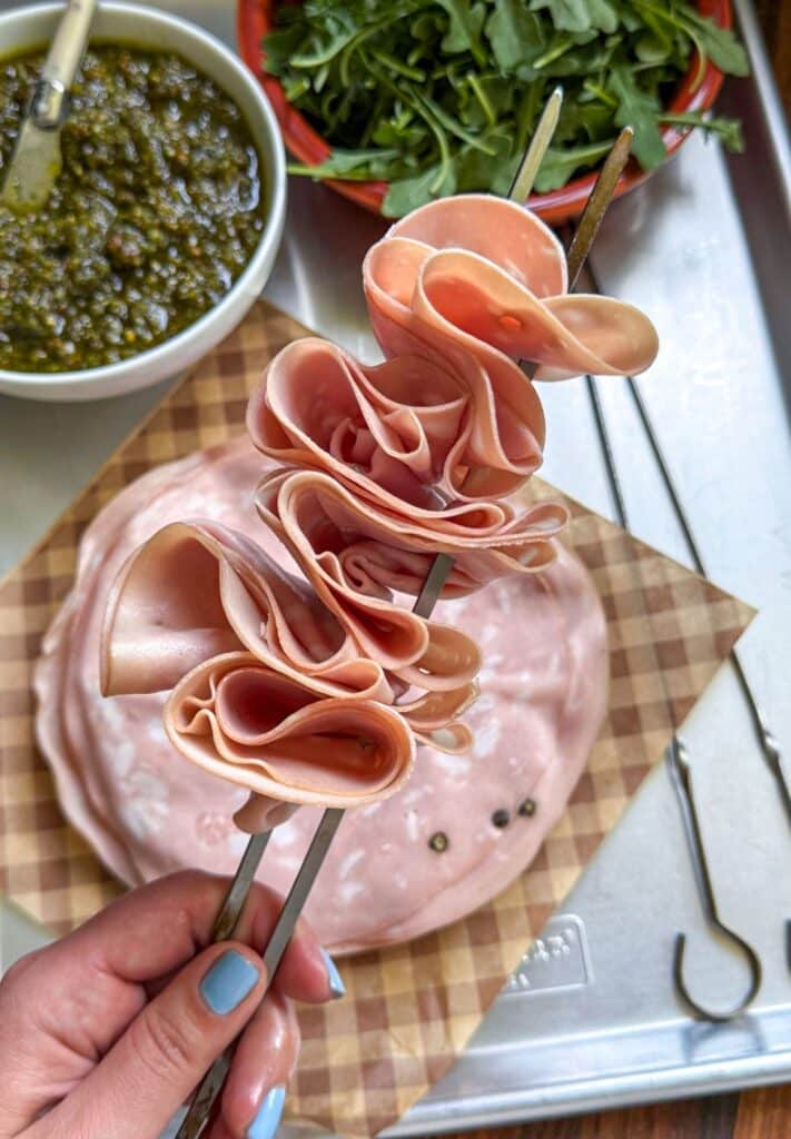 mortadella being added to the skewers