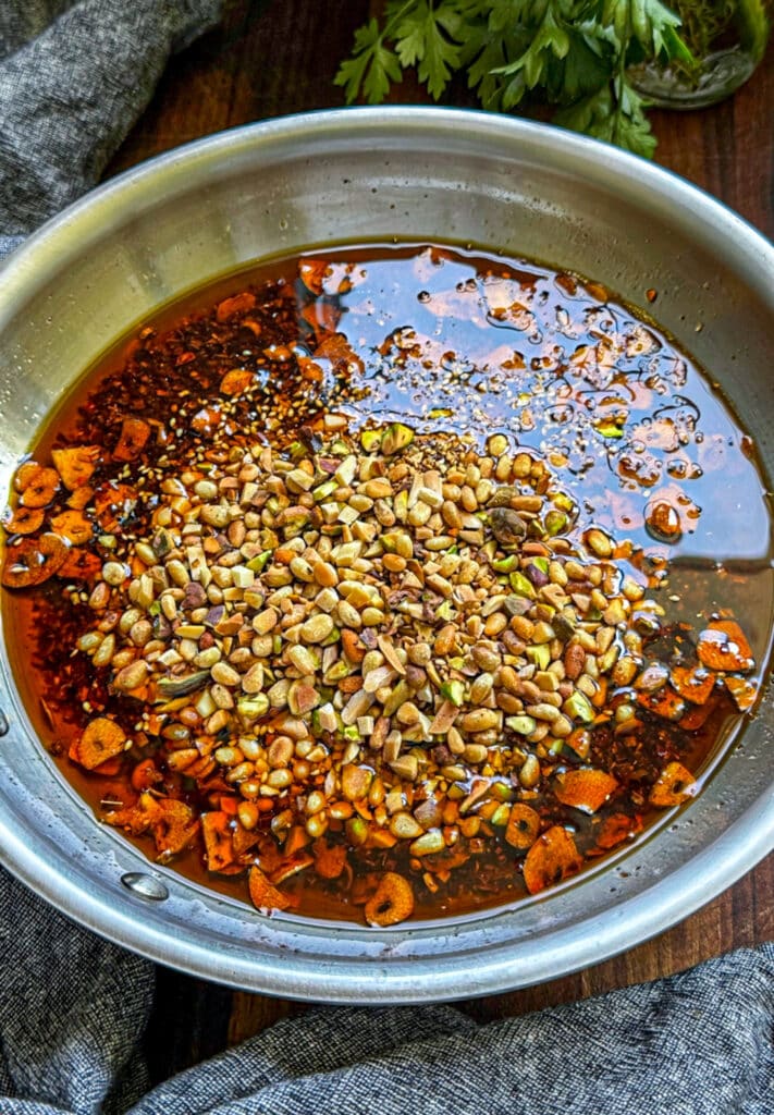 Folding the roasted nuts into the oil and spices