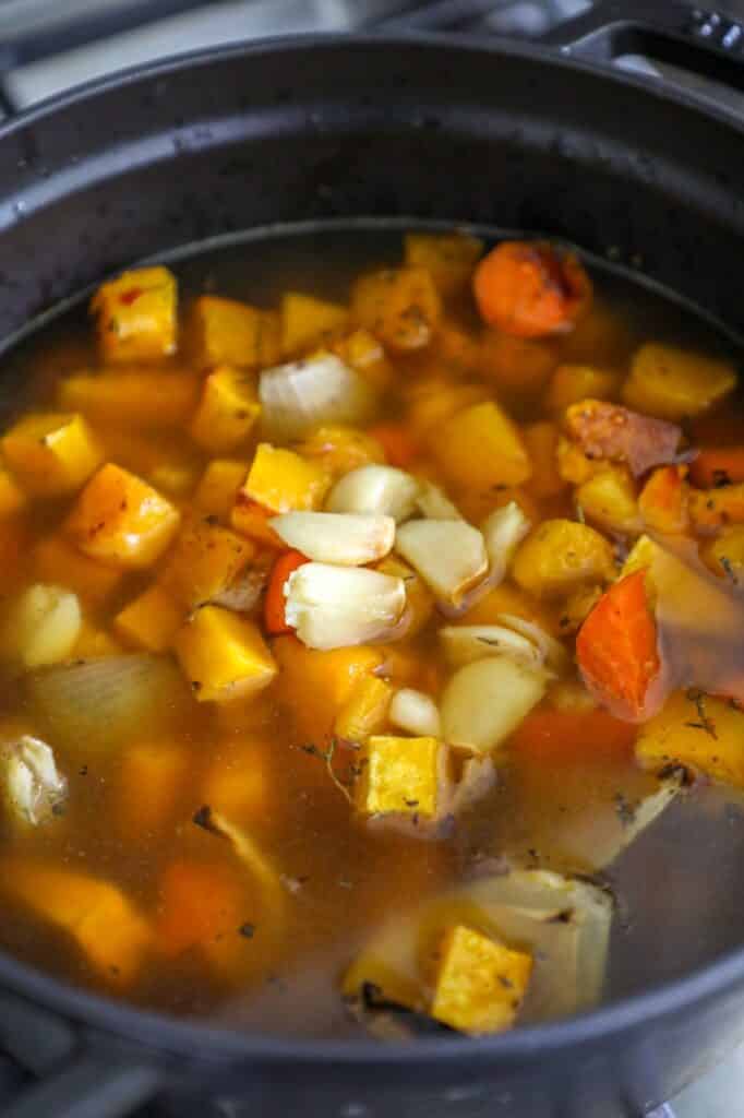 adding the roasted vegetables and then adding the chicken stock