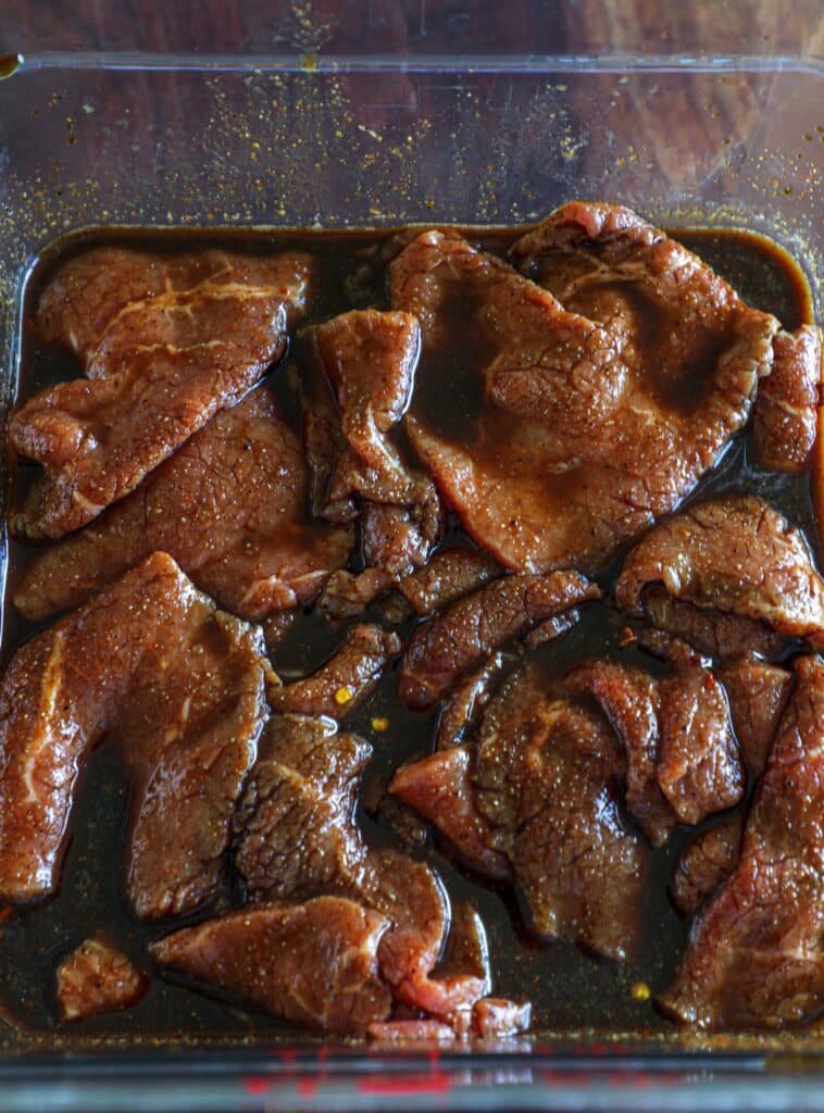 the slices of beef sitting in the marinade