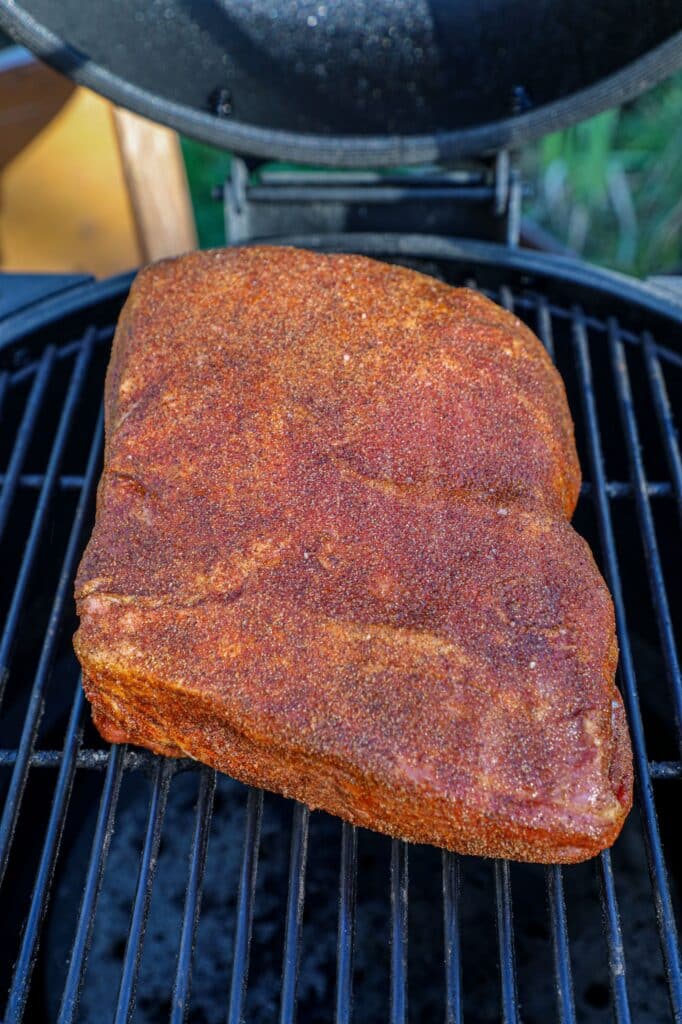 the pork shoulder on the grill grates ready to smoke